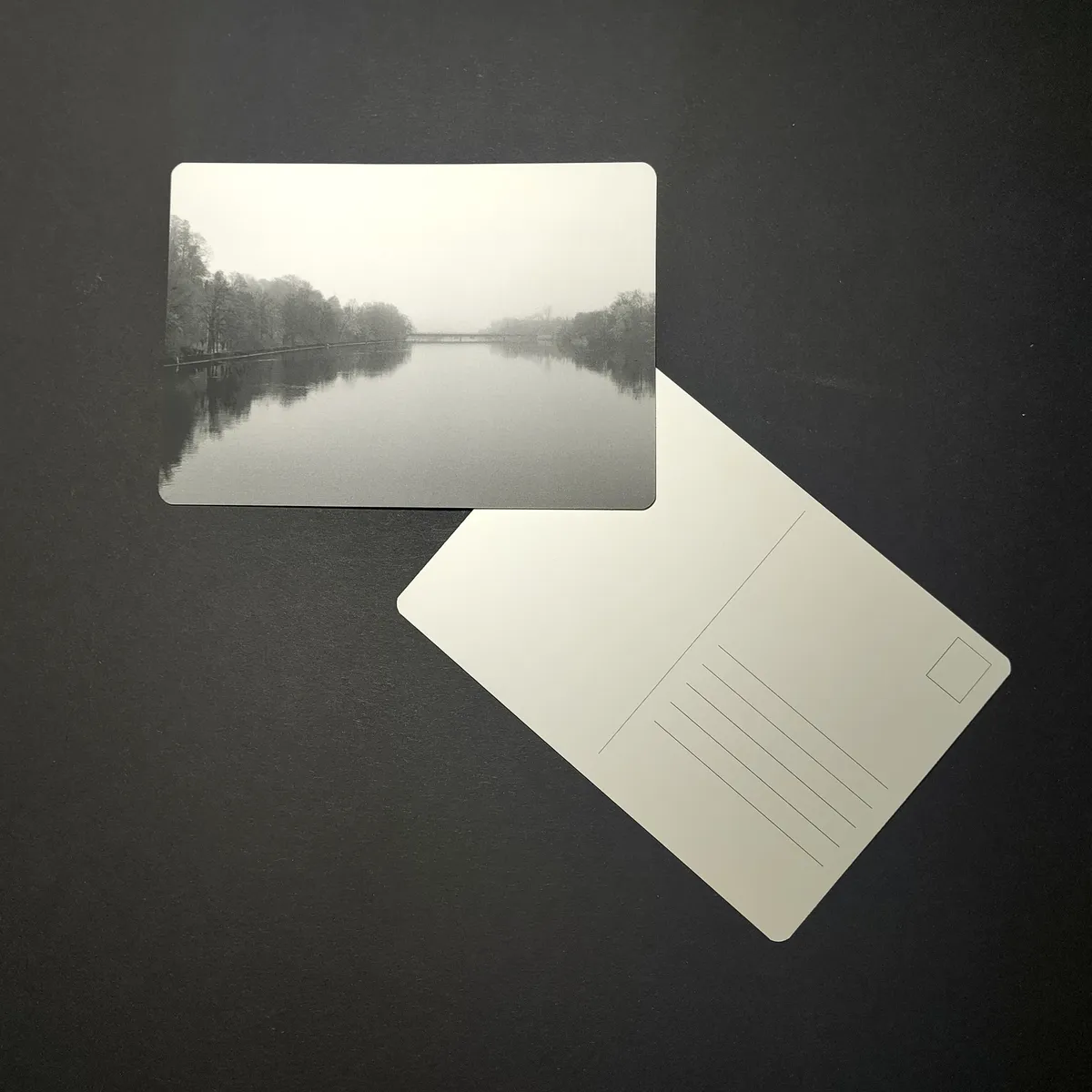 October Postcard - Black-and-white photo of the Aare at Attisholz near Solothurn, with a bridge fading into fog and trees reflected in the still water
